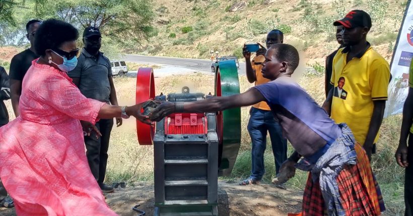 Moroto Resident District Commissioner, Jane Francis Okili Amongin hands over a stone quarrying machine to a group of women at one of the communities in Moroto. Photo Credit: RIAMIRIAM CSO Network